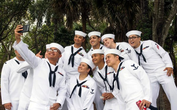 Image of a group in Navy uniforms taking a selfie